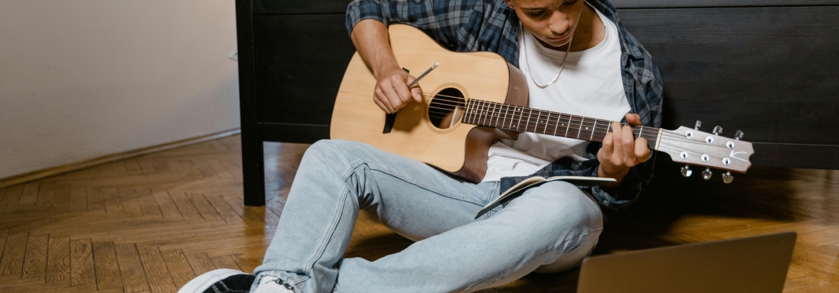 young male musician playing acoustic guitar