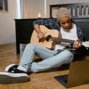 young male musician playing acoustic guitar