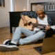 young male musician playing acoustic guitar